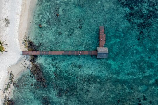 Aerial view of people on a jetty along the coastline in Pointe aux Piments, Pamplemousses, Mauritius.