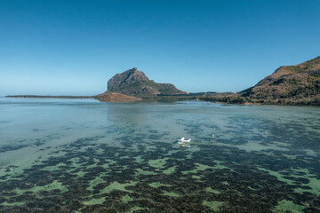Aerial view of a water airplane landing in a lagoon with barrier reef with Le Morne Mountain in background, Le Morne Brabant, Riviere Noire, Mauritius.