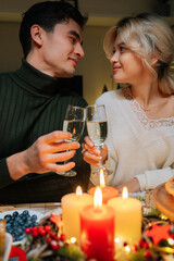 Vertical shot of beautiful young couple clinking glass of champagne looking at each other. Happy romance new marriage man and woman having dinner night party to celebrate wedding anniversary together.