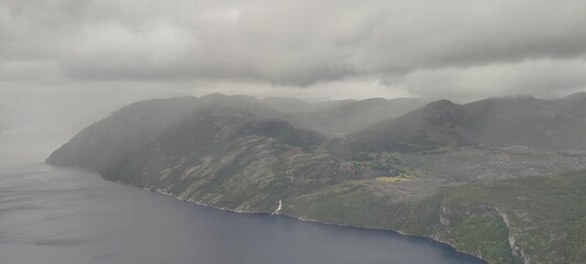 Beautiful landscape of a fjord surrounded by the big mountains on a foggy and gloomy day