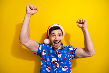 Photo of young guy fists up yeah surprise buy more gifts santa claus headwear merry christmas...