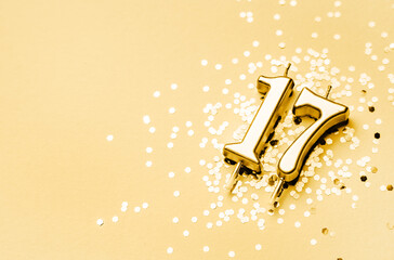 17 years celebration festive background made with golden candle in the form of number Seventeen...