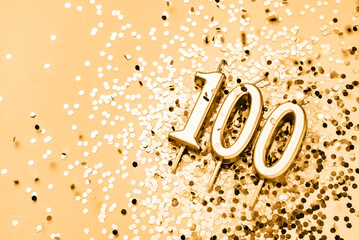 100 years celebration festive background made with golden candles in the form of number Hundred...
