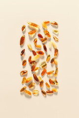 Nature gemstone amber stones at sunlight, yellow orange gradient color on beige background. Natural mineral. Aesthetic Amber gems flat lay vertical pattern, still life pieces ancient resin