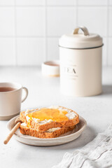 Toasts with butter and honey on light kitchen background. Homemade breakfast sandwich. Healthy vegan food concept