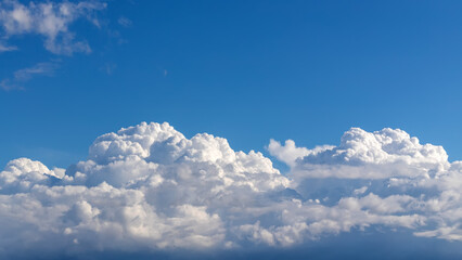 The white cumulus clouds with sun on blue sky.
