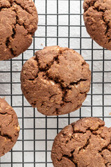 Chocolate brownie cookies with crack on cooling rack on white background. Homemade crinkle cookies
