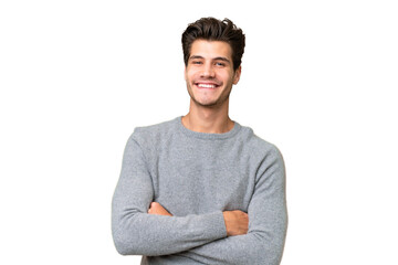 Young handsome caucasian man over isolated background keeping the arms crossed in frontal position