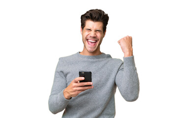 Young handsome caucasian man over isolated background with phone in victory position