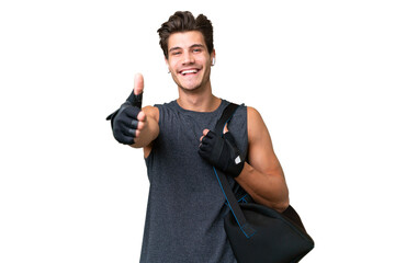 Fototapeta premium Young sport caucasian man with sport bag over over isolated background with thumbs up because something good has happened