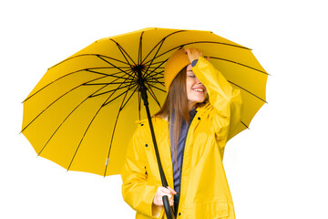 Young pretty woman with rainproof coat and umbrella over isolated chroma key background has...