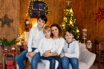 Happy family, children and mom, taking family pictures in a cozy christmas studio