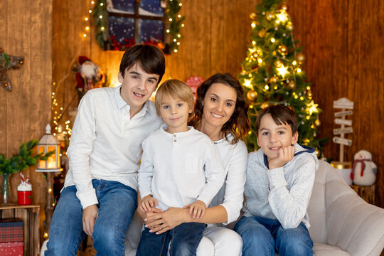 Happy family, children and mom, taking family pictures in a cozy christmas studio