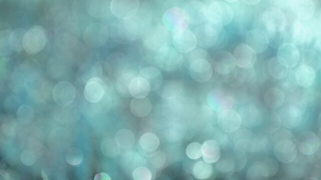 Defocused abstract bokeh background blue colored, flare from lights, beige monochrome photo, blurred round bokeh as holiday background, celebration wallpaper.