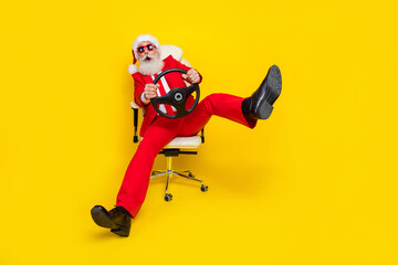 Photo of funky impressed retired guy wear red tux claus hat automobile driver rider isolated yellow...