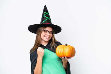 Young caucasian woman costume as witch holding a pumpkin isolated on white background celebrating a victory