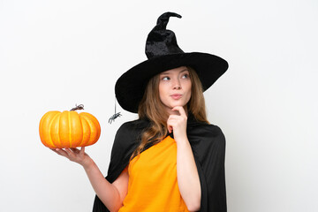 Young pretty woman costume as witch holding a pumpkin isolated on white background having doubts and thinking