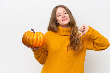 Young pretty woman holding a pumpkin isolated on white background proud and self-satisfied