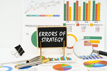 Against the background of business graphs, a board with the inscription - Errors of strategy