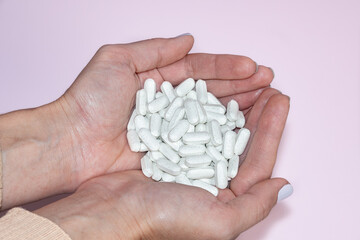 Woman holding pills in her hands. Drugs use for treatment the disease.