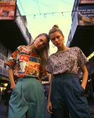 Obraz premium Generative ai two young and beautiful woman gracefully posing on the city streets