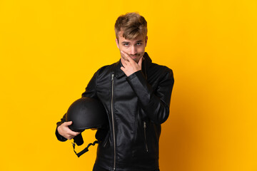 Man with a motorcycle helmet isolated on yellow background thinking