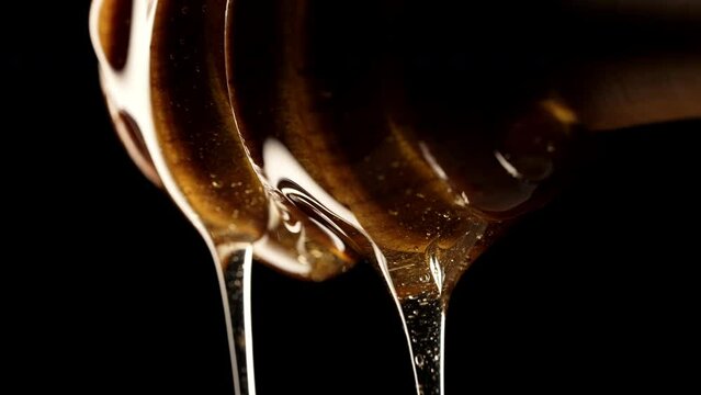 Natural honey dripping, wooden dipper stick, tasty macro details. Sweet essence