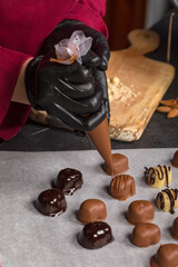A confectioner decorates sweets with the help of a confectioner's bag