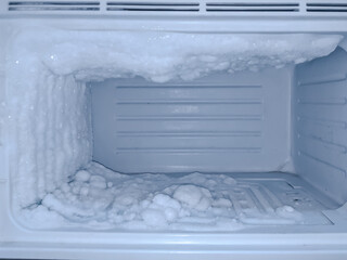 Fototapeta na wymiar empty freezer of a refrigerator - lce buildup on the inside of a freezer walls.