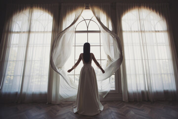 Bride near the window. the bride in a wedding dress opens the curtains of the window, stands back, you can see her silhouette, against the light, boudoir morning of the bride. wedding day. - obrazy, fototapety, plakaty