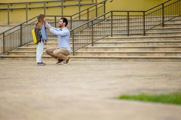 Dark-haired man sending his daughter to school