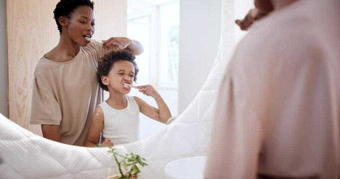 Woman, child or brushing teeth in mirror in bathroom, learn or dental hygiene for care in house. Mom, son or smile by toothpaste on toothbrush, clean mouth reflection or teaching oral health at home