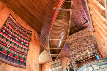 Canoe suspended from the ceiling in log cabin.