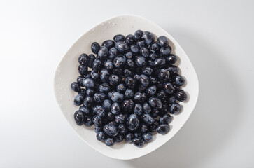 Blue grapes bunches on white plate. Healthy nutrition, health