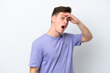 Young handsome Brazilian man isolated on white background doing surprise gesture while looking to the side
