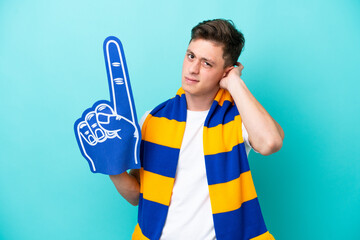 Young sports fan man isolated on blue background having doubts