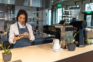 Fototapeta premium Short-haired pretty girl in apron in a coffee shop
