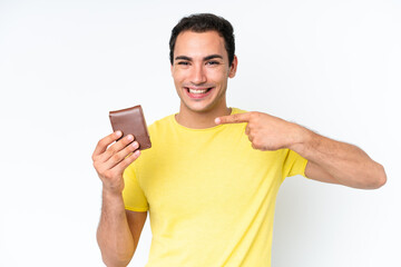 Young caucasian man holding a wallet isolated on white background and pointing it