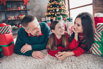 Naklejka premium Full size photo of lovely positive people lying carpet floor touch hands enjoy newyear time giftbox tree decor indoors