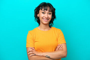 Young Argentinian woman isolated on blue background keeping the arms crossed in frontal position - obrazy, fototapety, plakaty