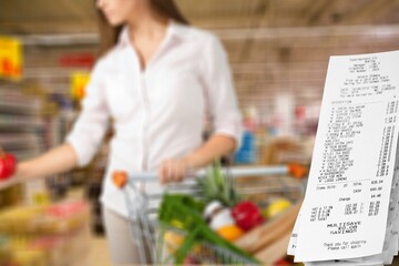 Woman with supermarket trolley and big check - obrazy, fototapety, plakaty