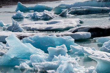 Ice floes in a glacial lake in Iceland with vulcano mountains in the background, the climate crisis in northern Europe, glacial melting, beautiful landsacpe