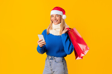 Happy woman with phone and shopper bags