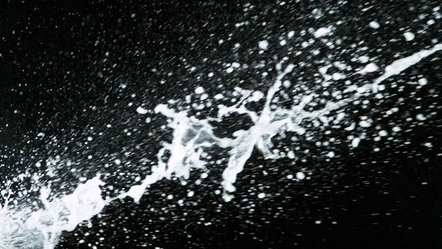 Super slow motion of Champagne explosion with flying cork closure, black background, opening champagne bottle closeup.