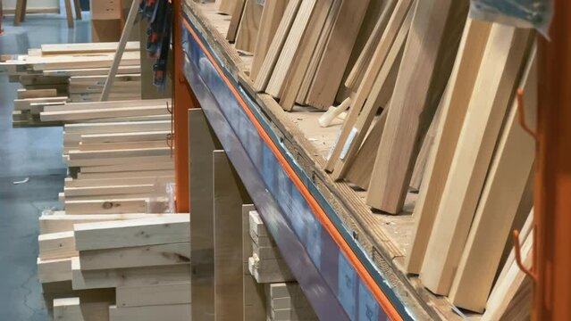 Joinery, wooden skirting boards, cornices lined up on the shelf of a DIY, carpentry or hardware store