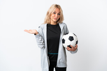 Young Russian woman playing football isolated on white background having doubts while raising hands