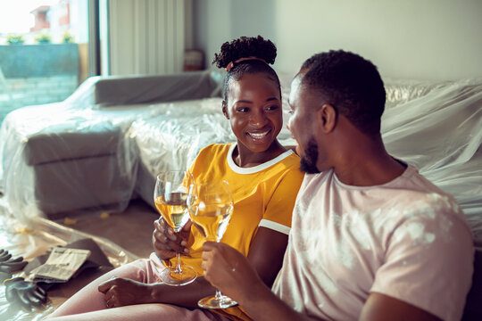 Young couple having wine after renovating home