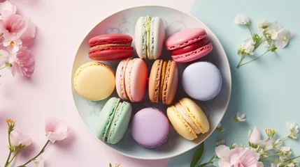 Foto op Plexiglas Macarons  a plate of colorful macaroons and flowers on a blue and pink background with space for text or image.