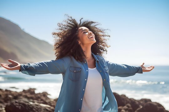 african woman stretching her arms enjoying vacation on the beach