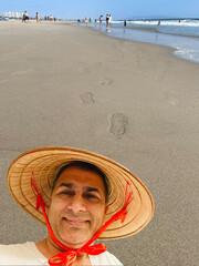 man with a traditional hat on a beach